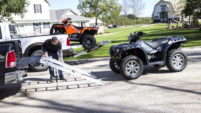 Man loading ATV onto truck using Mad-Ramps